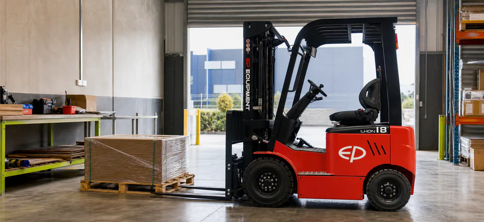 EP EFL181 compact lithium forklift carrying a pallet in a small warehouse